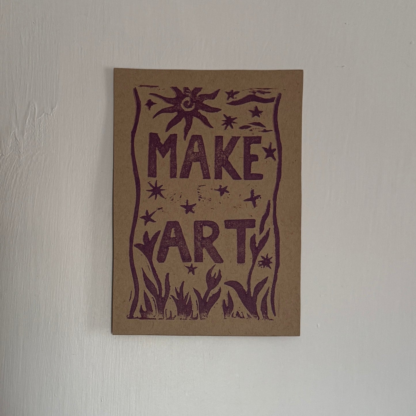 Brown card with purple 'MAKE ART' text on a light gray background
