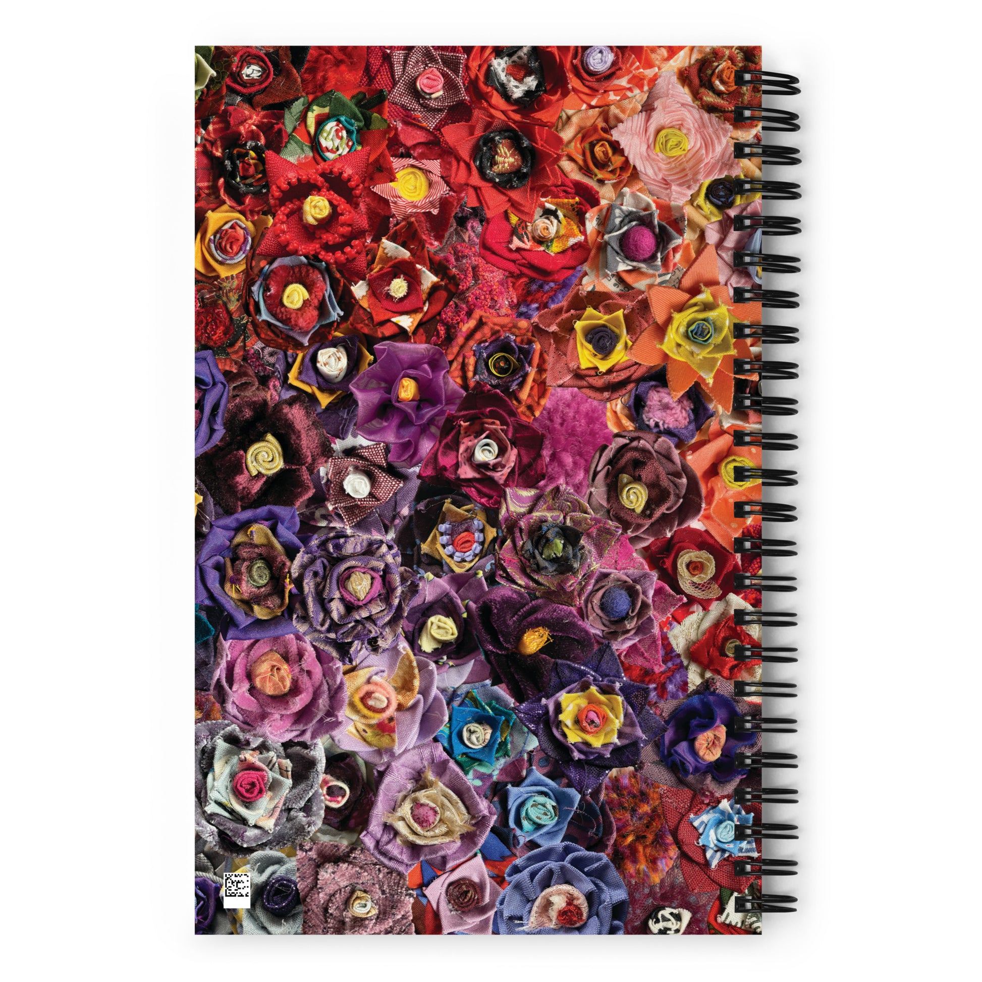 Spiral bound notebook with a pink and purple image of fabric flowers