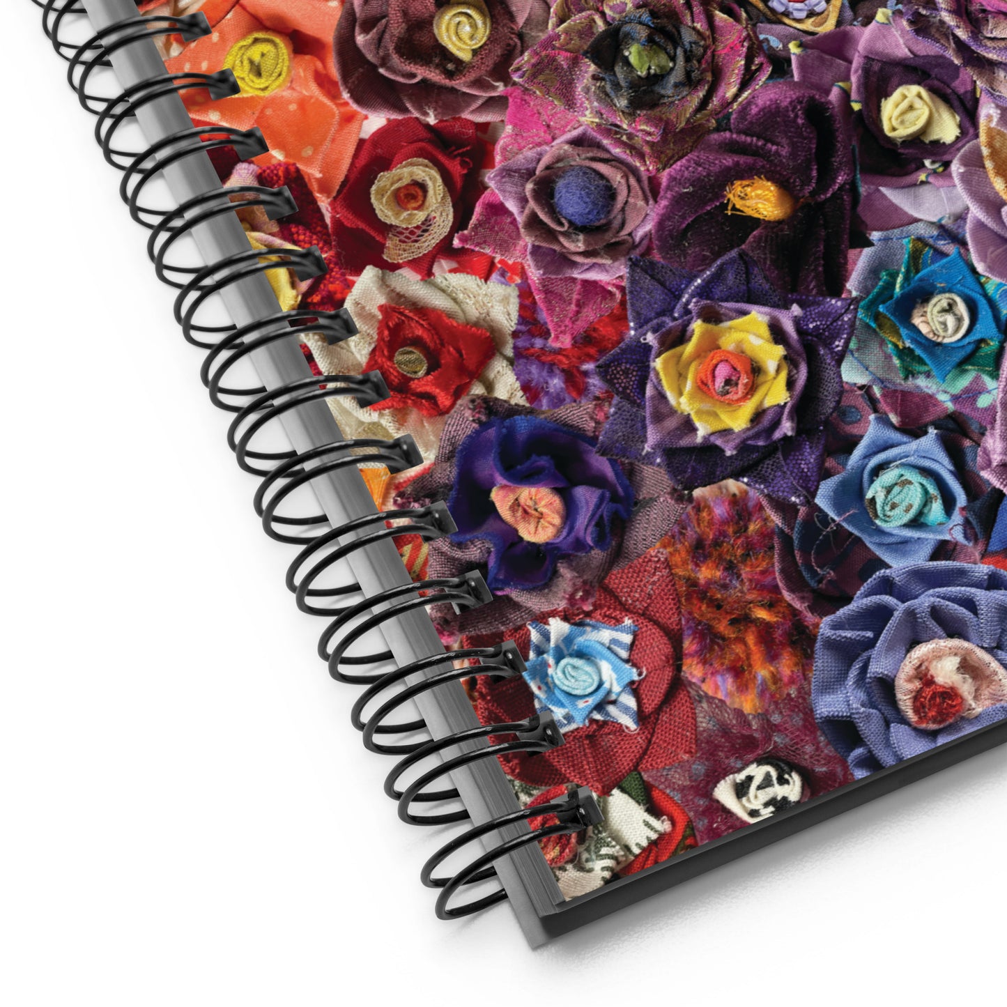 Close up image of notebook with a pink and purple image of fabric flowers