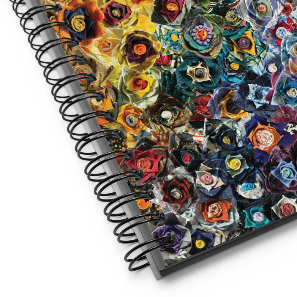 Spiral bound notebook with a rainbow image of fabric flowers