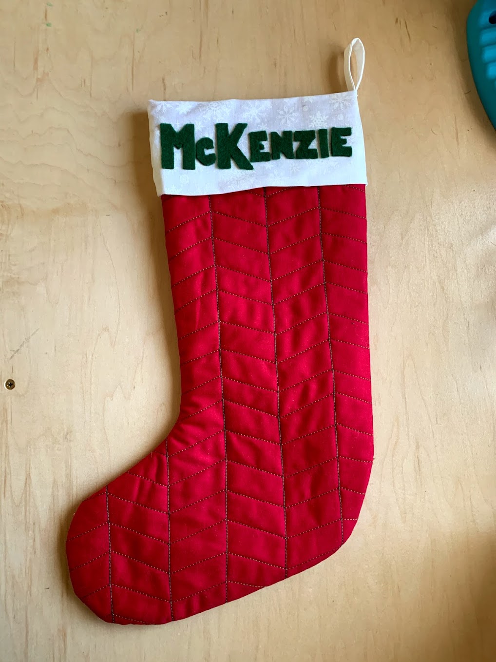 Red Christmas stocking with the name McKenzie in green felt