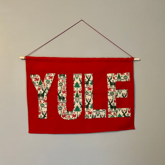 Red banner with the word YULE in patterned fabric