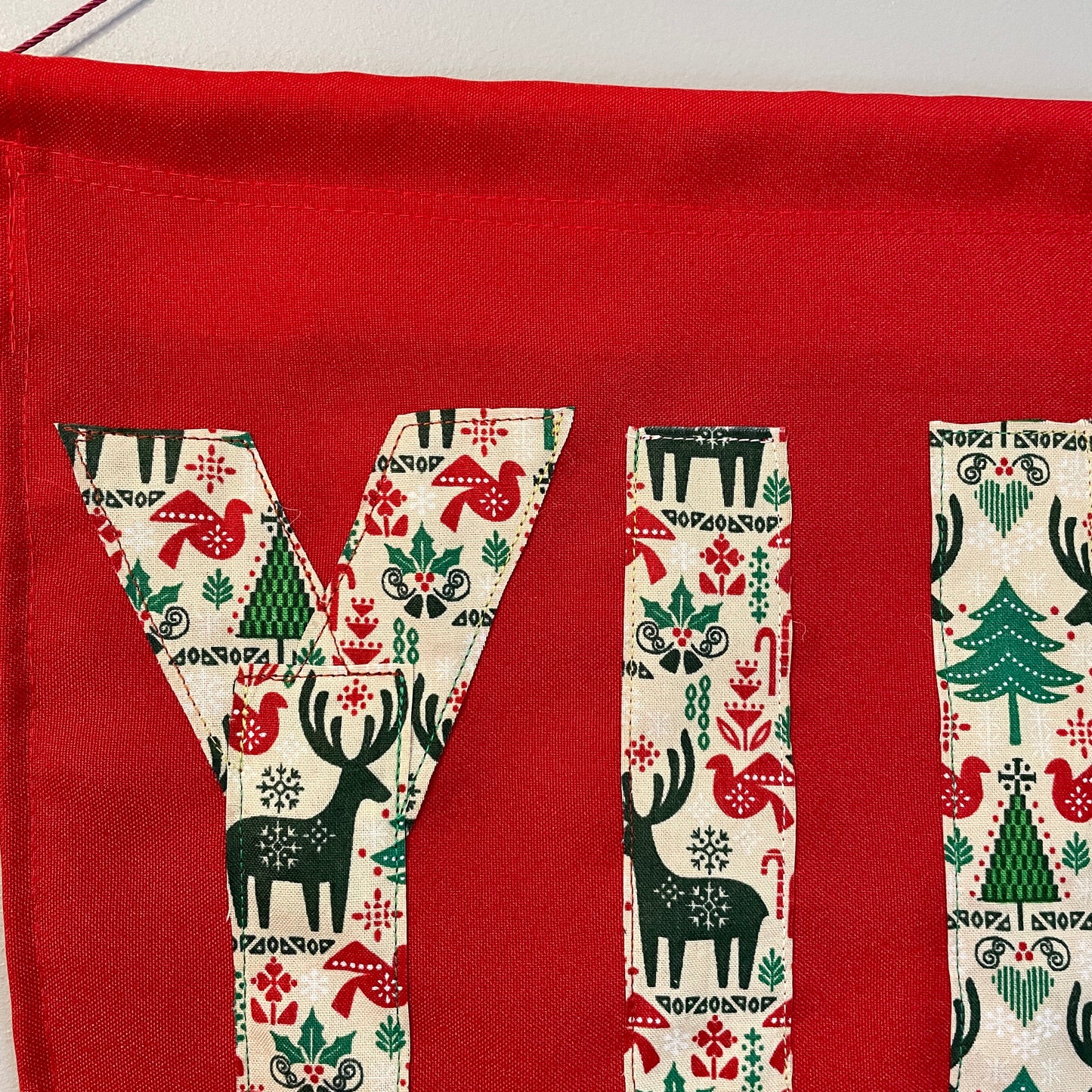 Red banner with the word YULE in patterned fabric