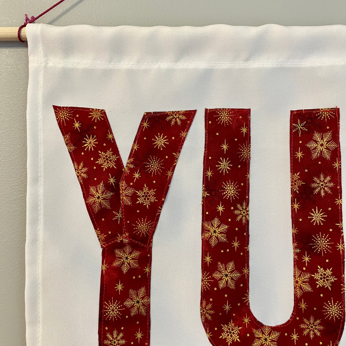 White banner with the word YULE in red fabric