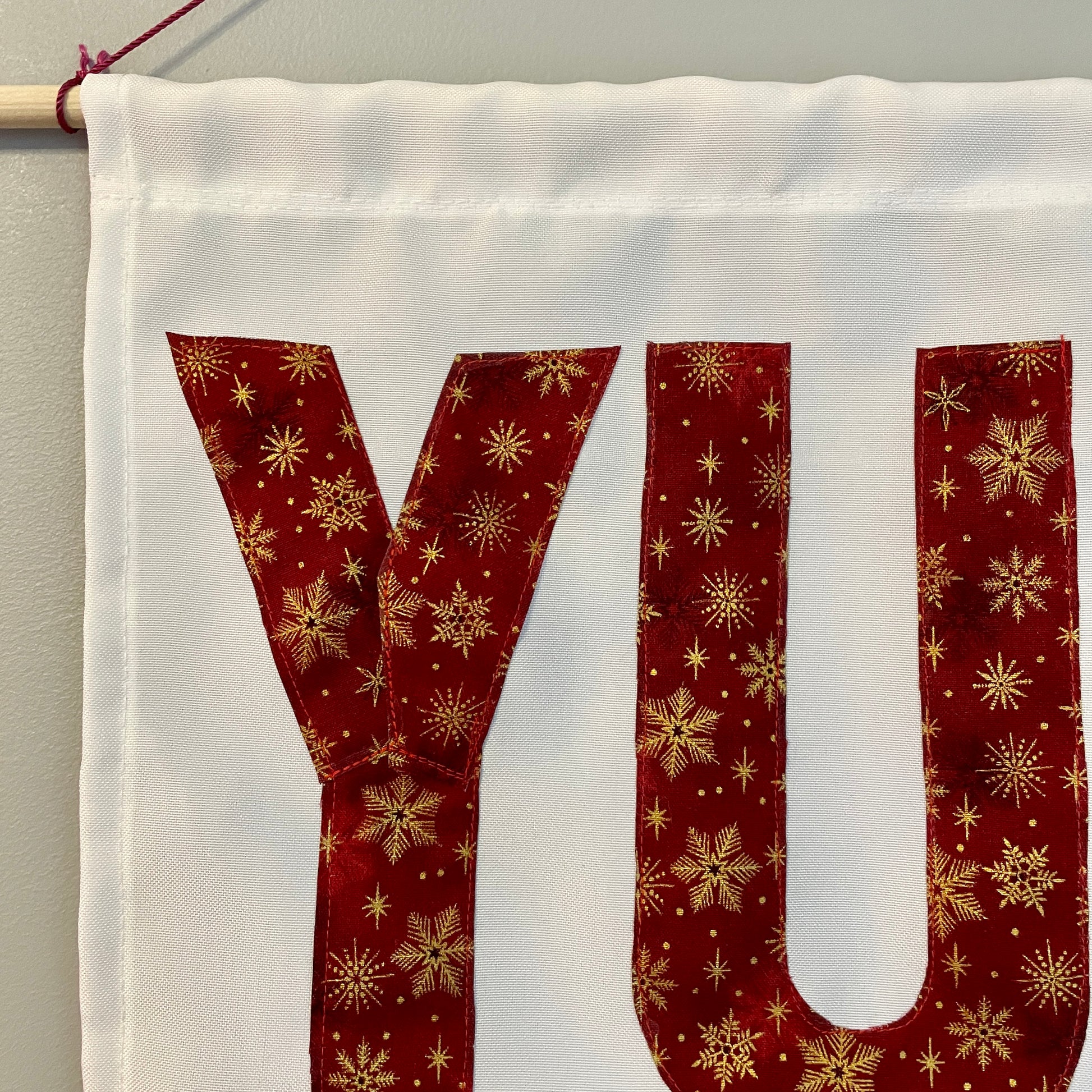 White banner with the word YULE in red fabric
