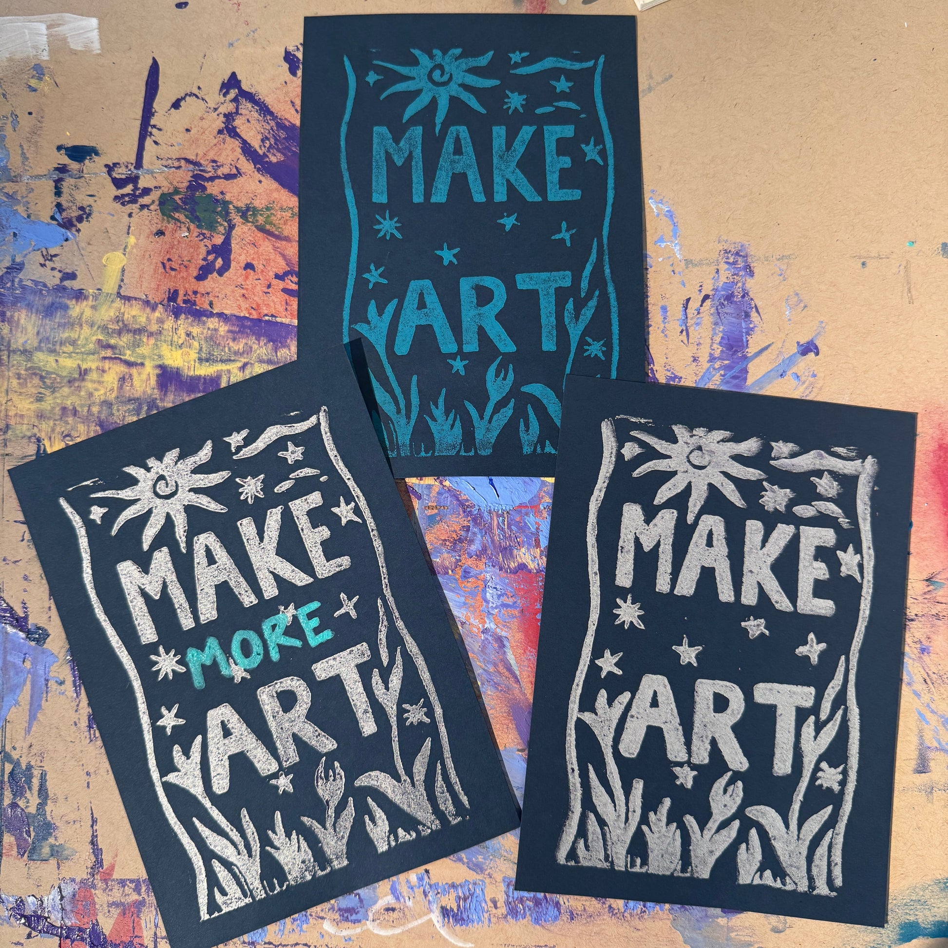 Three black cards with white and blue text reading "Make Art"