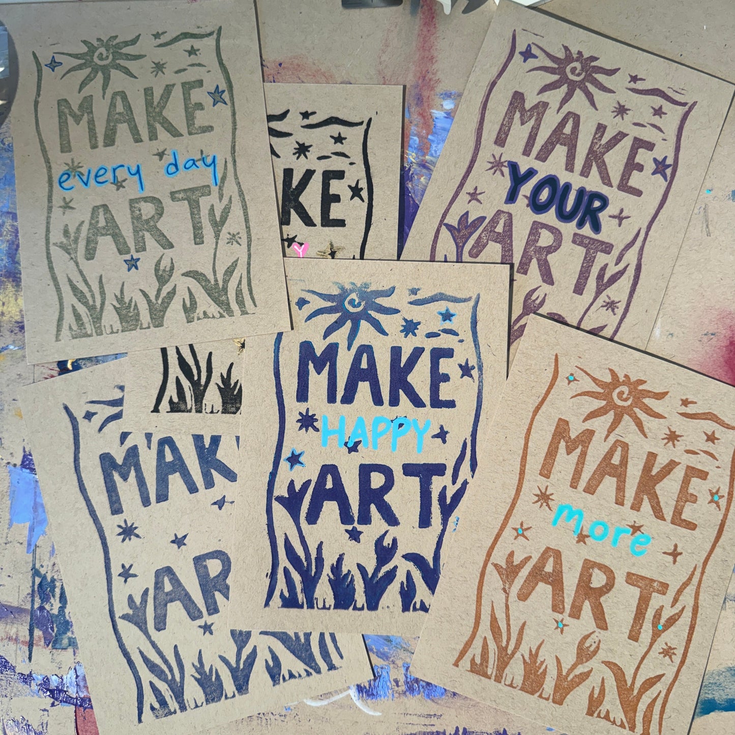 Multiple tan cards with text reading "Make Art" in different colors