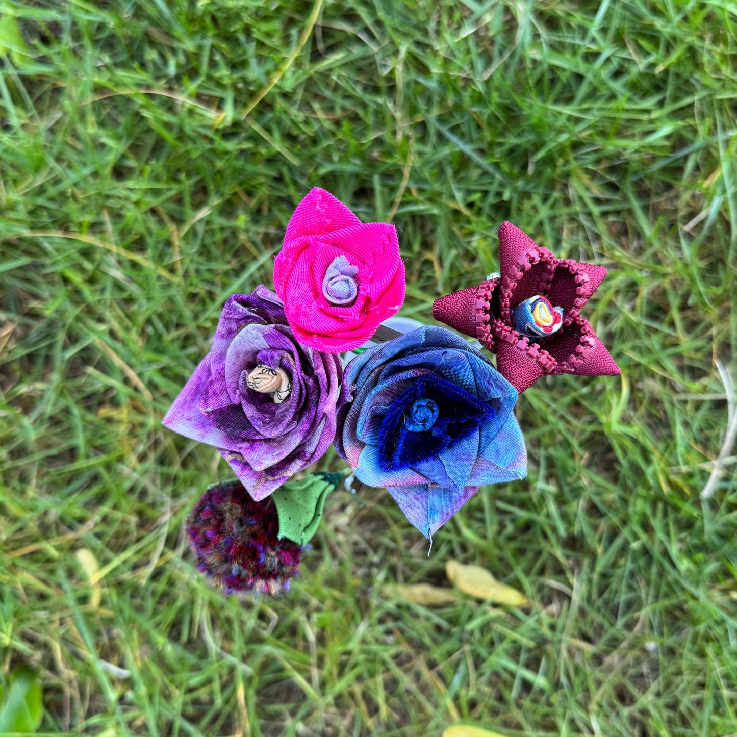 Colorful fabric flowers on a grassy background