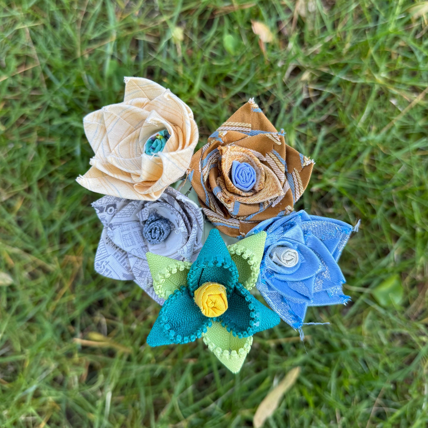 Colorful fabric flowers arranged on grass