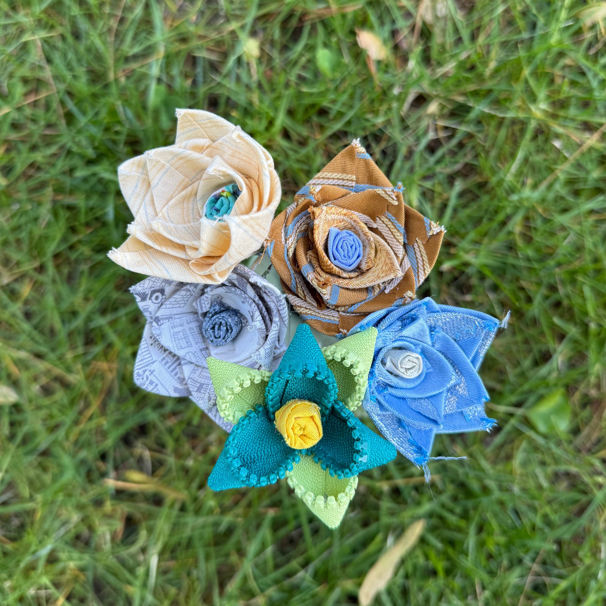Colorful fabric flowers arranged on grass