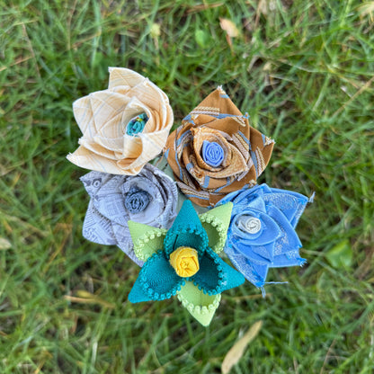 Colorful fabric flowers arranged on grass