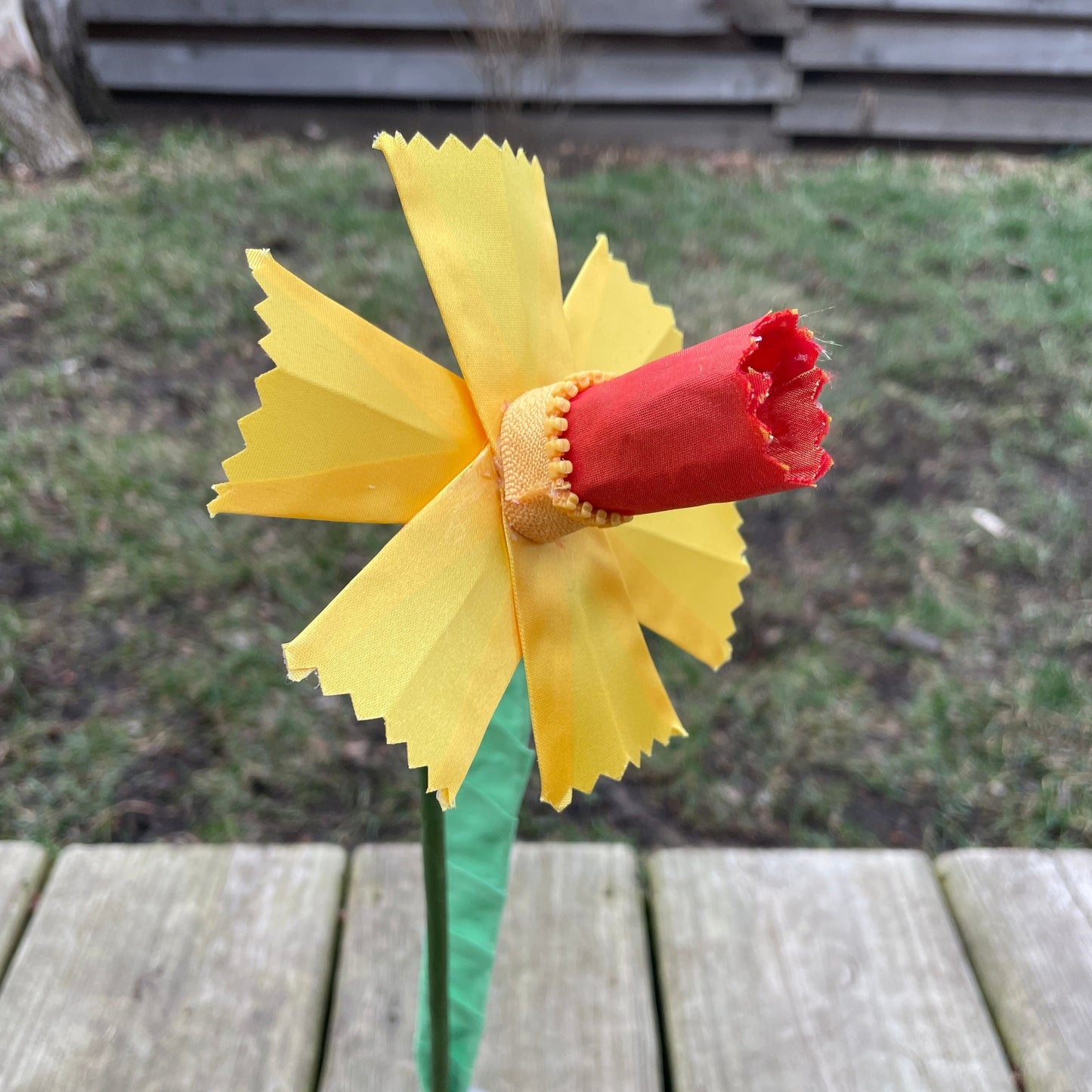 A daffodil made out of yellow ribbon and fabric