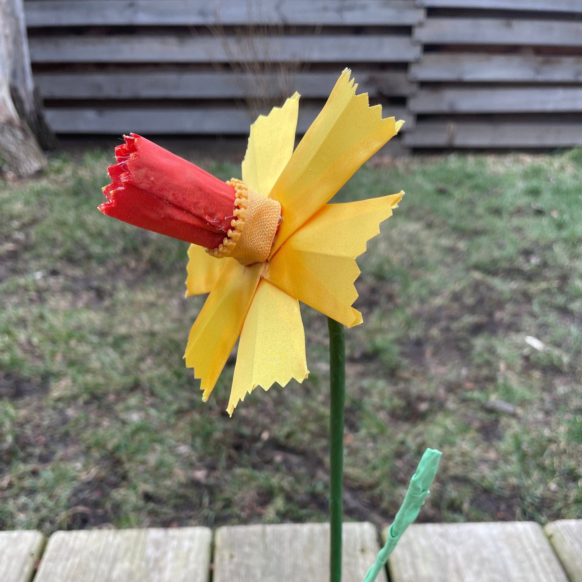 A daffodil made out of yellow ribbon and fabric