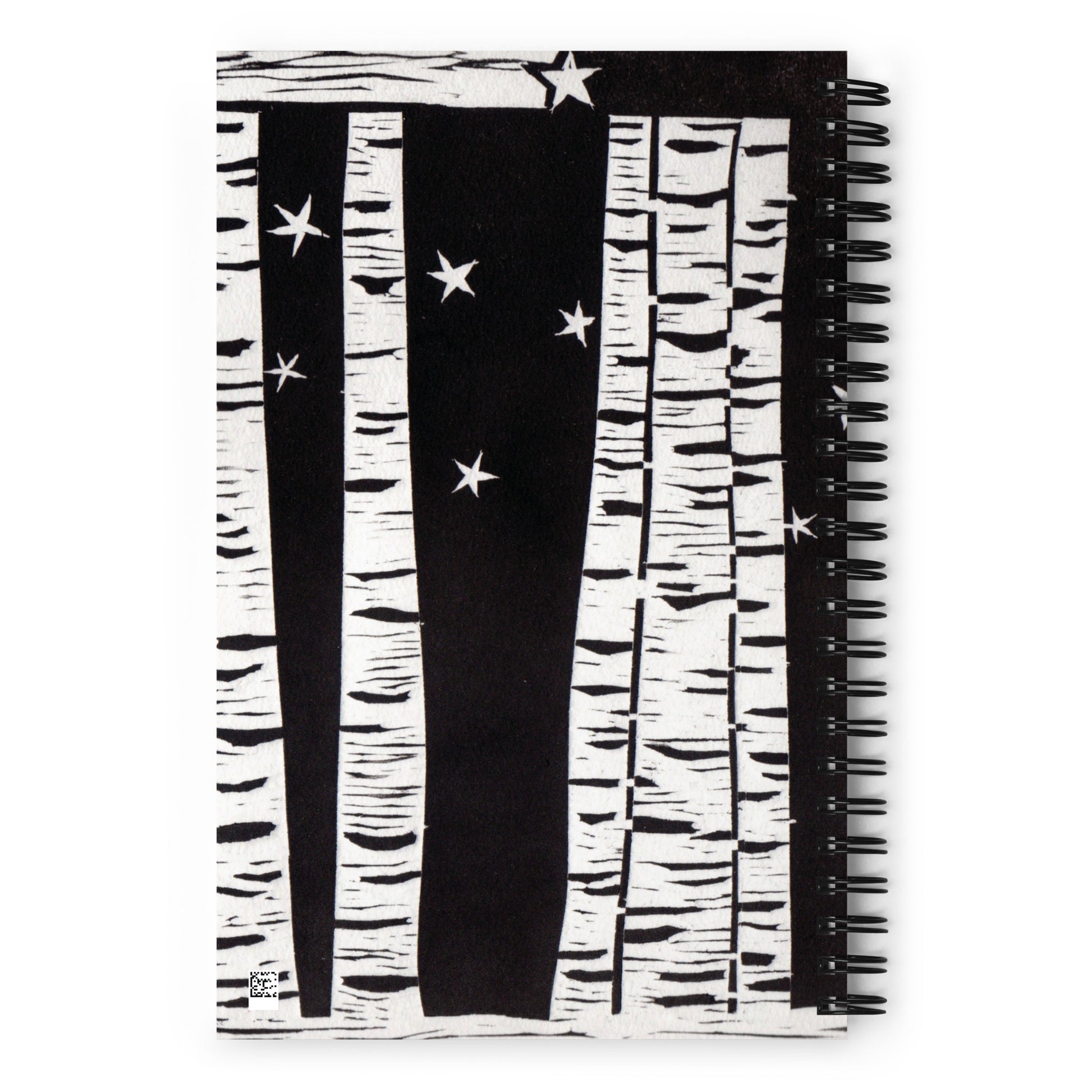 A notebook with a black and white image of trees and stars