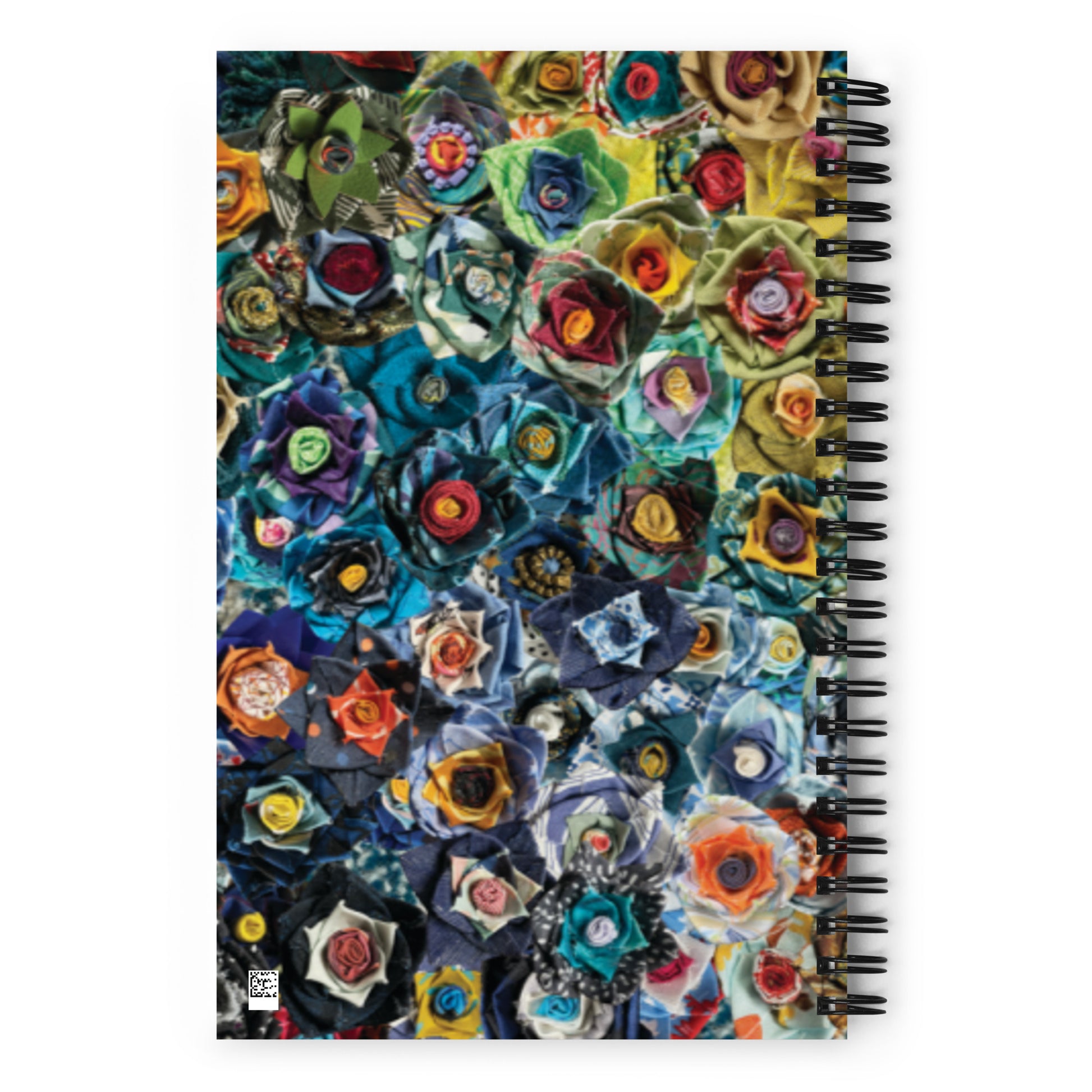 Spiral bound notebook with a blue and green image of fabric flowers