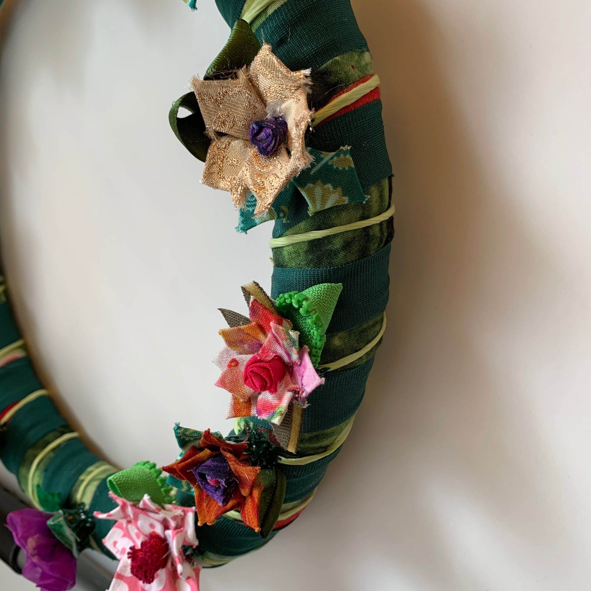 Wreath with fabric flowers around it