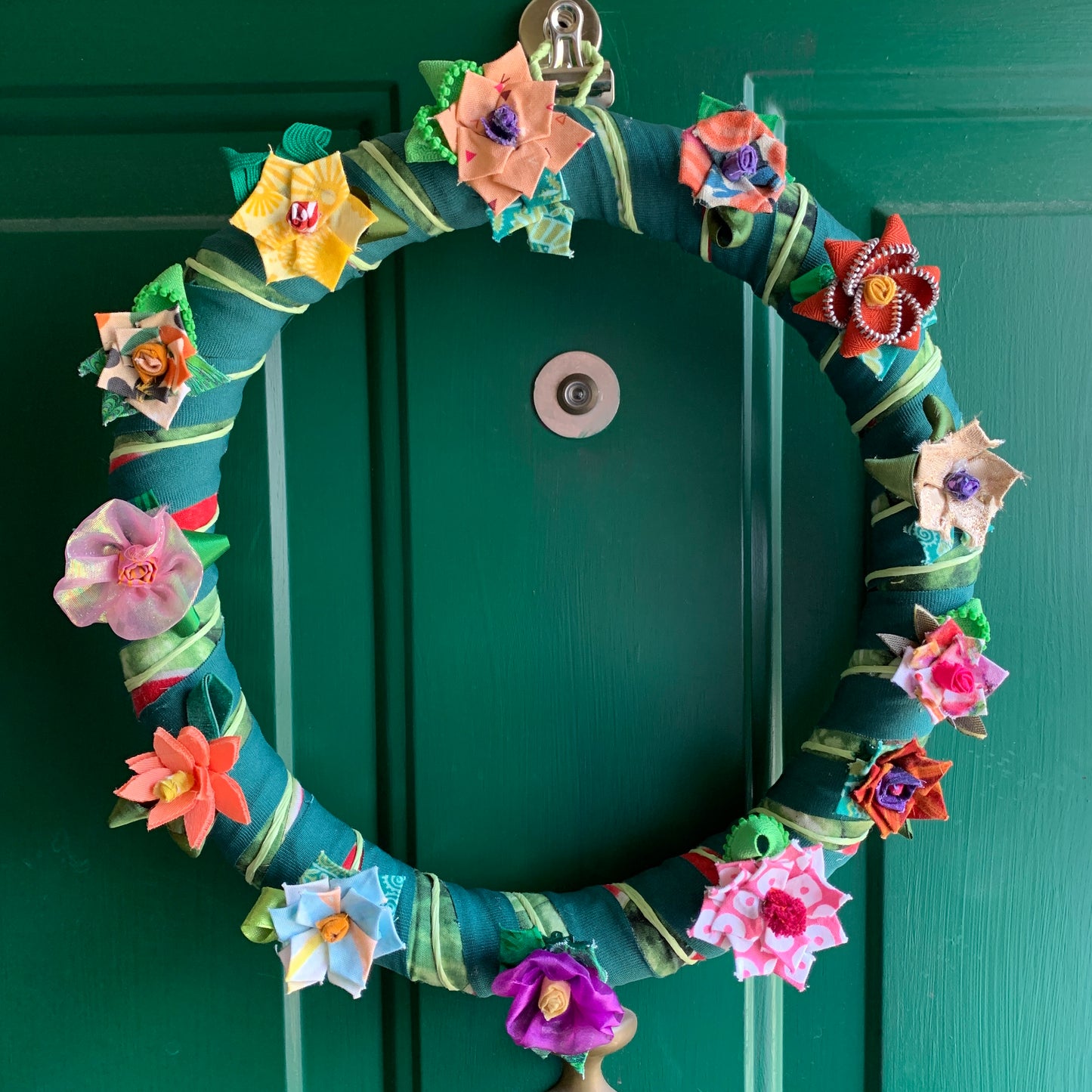 Wreath with flowers hanging on a green door