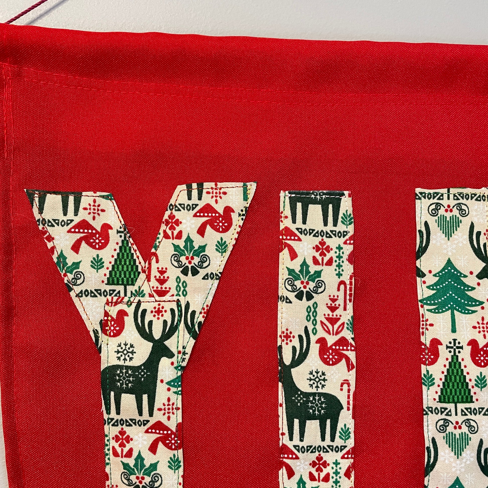 Red banner with the word YULE in patterned fabric 